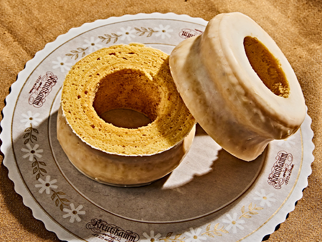 Zwei glasierte Kuchenringe liegen auf einem kreisrunden Papier mit der Aufschrift 
