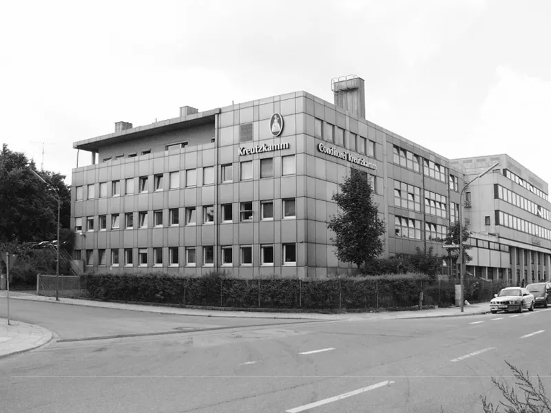 Gebaeude mit Aufschrift Kreutzkamm, Conditorei Kreutzkamm, neben Strassenkreuzung, Autos geparkt.