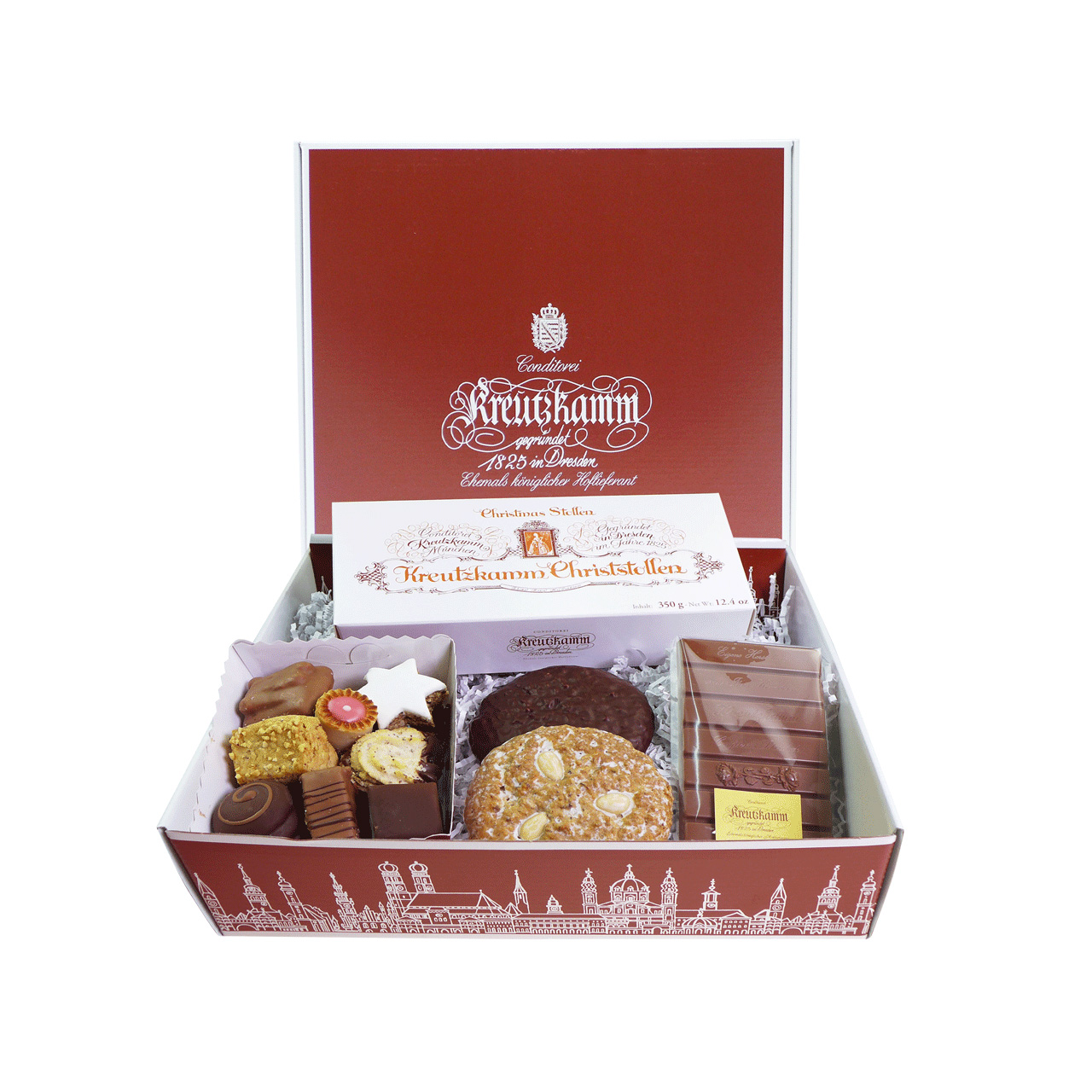 Geschenkbox mit Suessigkeiten, darunter Pralinen, Gebaeck, Schokolade und Christstollen, in geoeffneter, roter Verpackung. Text: "Kreutzkamm"